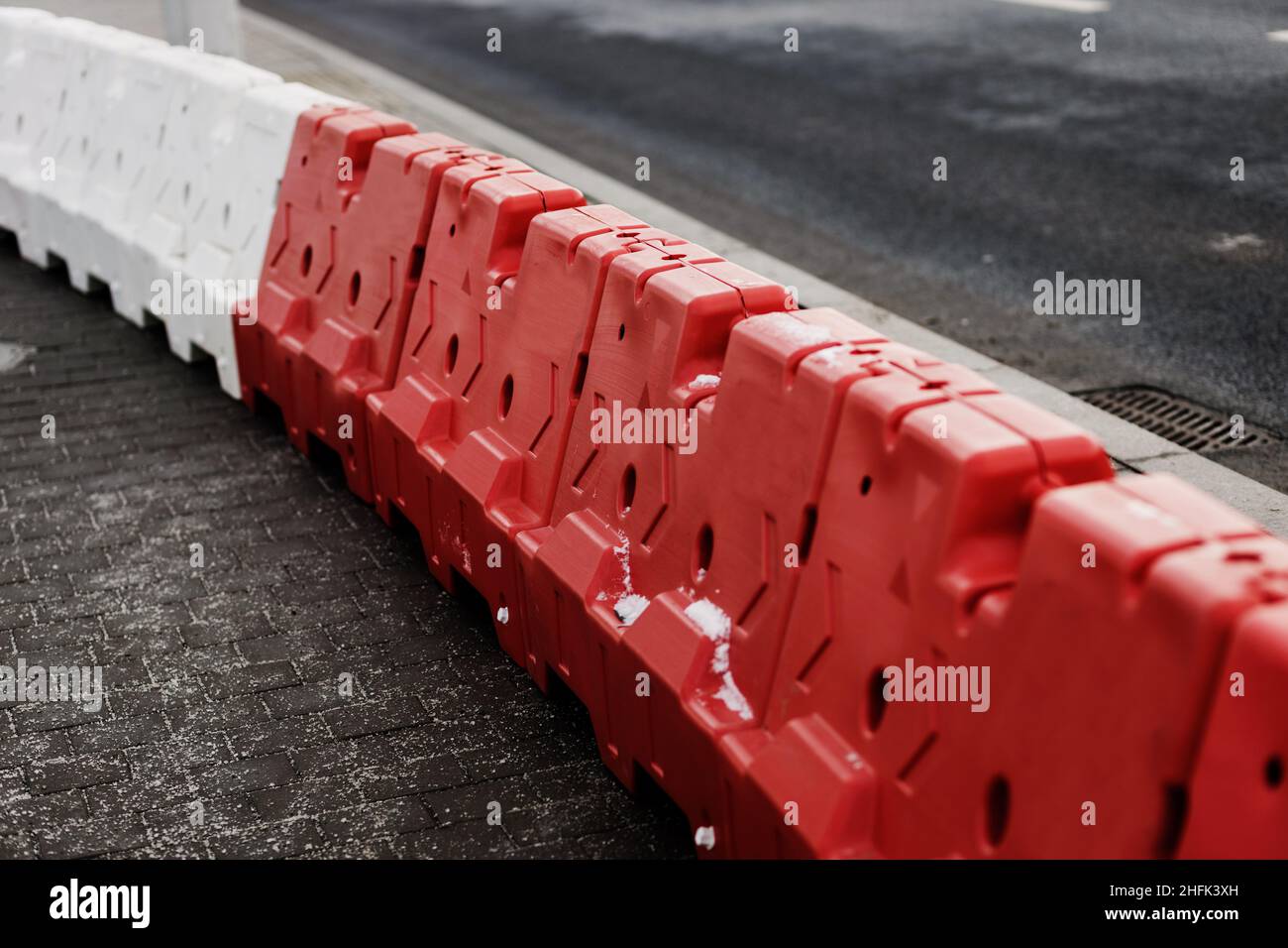 Red and white plastic barriers blocking the road Stock Photo