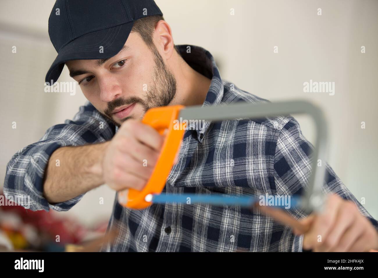 tradesman cutting copper pipe with hacksaw Stock Photo Alamy