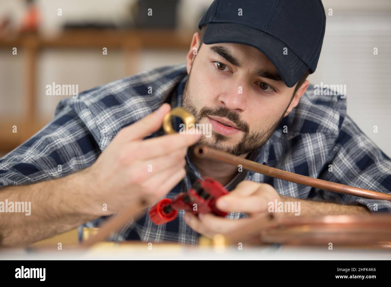 serious plumber using welding gas torch to solder copper pipes Stock