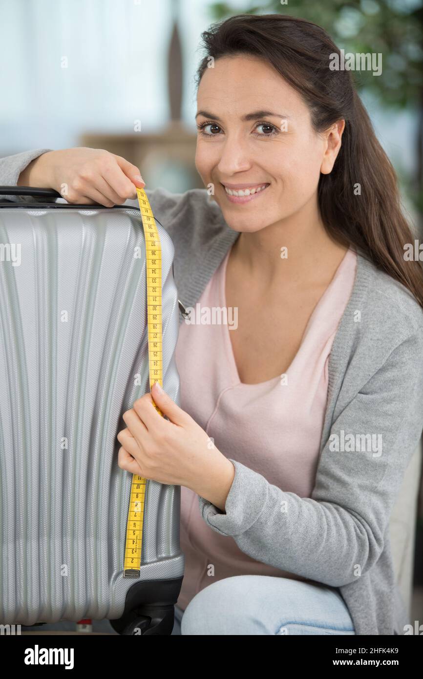 woman checking her luggage measurments before vacation Stock Photo