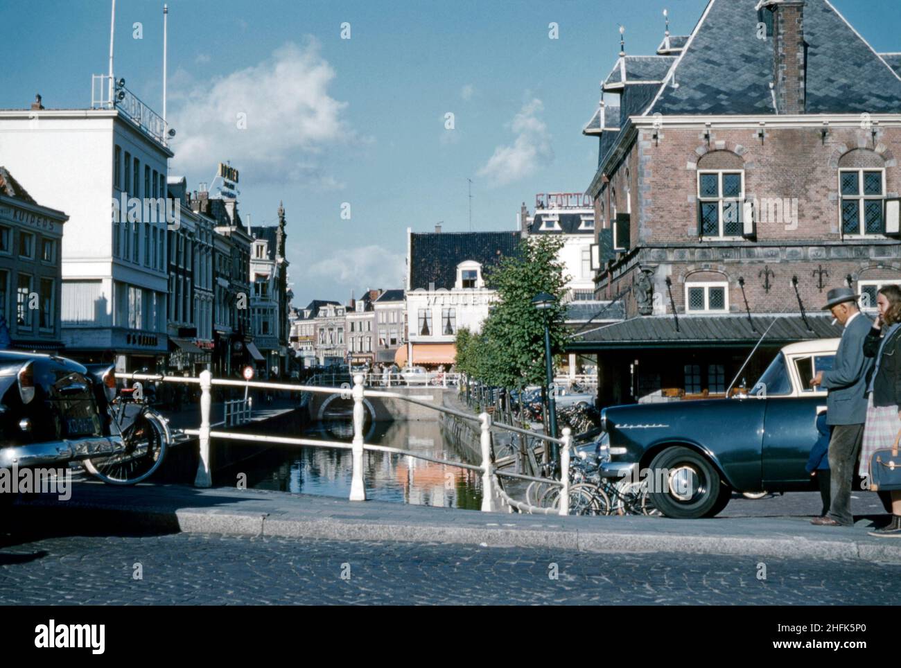 A view looking east from the canal bridge – the Waagplein crossing – in the centre of Leeuwarden, Friesland, the Netherlands in c.1960. The city is the provincial capital and seat of the Provincial Council of Friesland. It is the main economic hub of Friesland and is a former royal residence and has a city centre with many historic buildings – a vintage 1950s/1960s photograph. Stock Photo