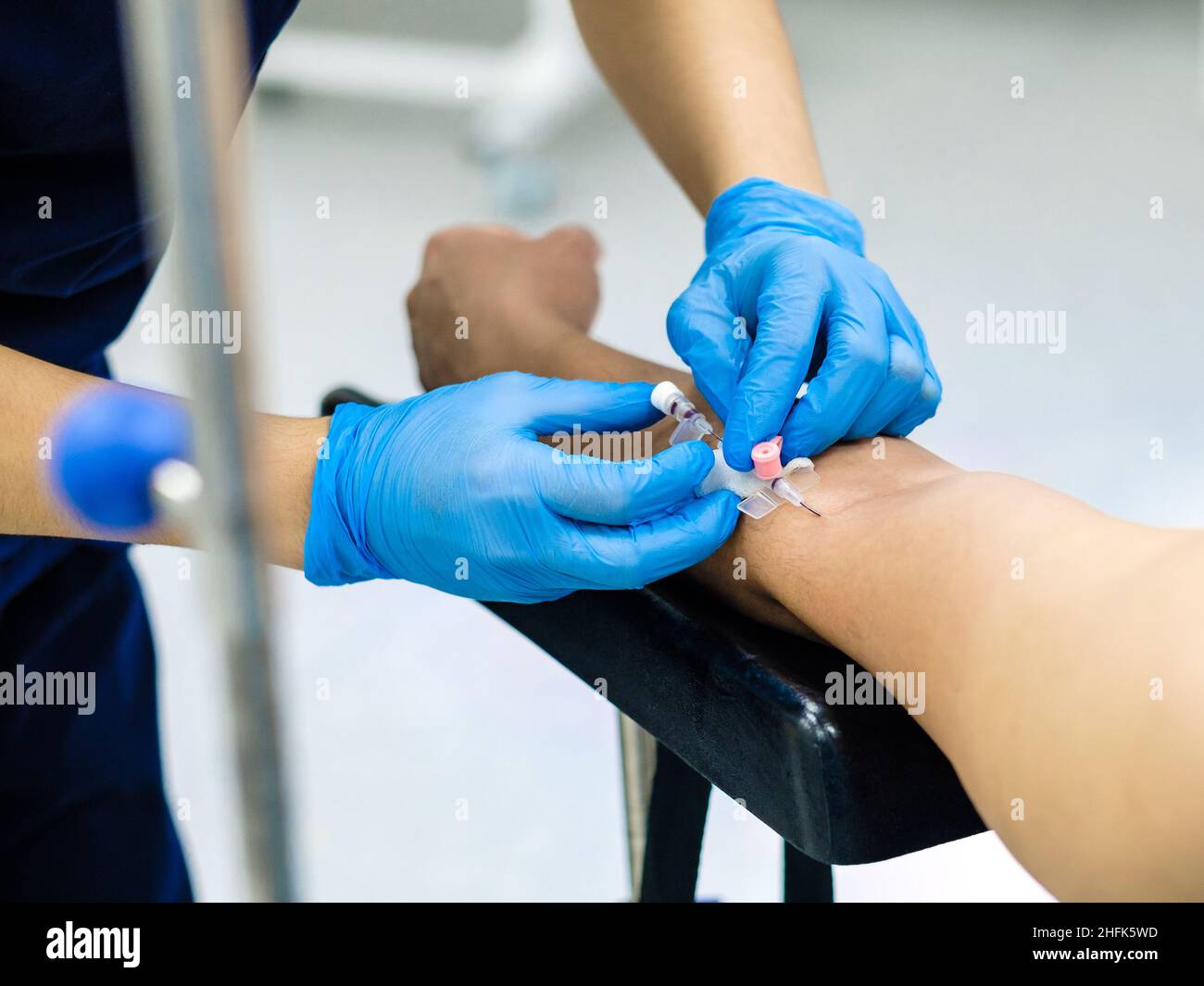 Inserting a catheter needle into a person's arm for intravenous