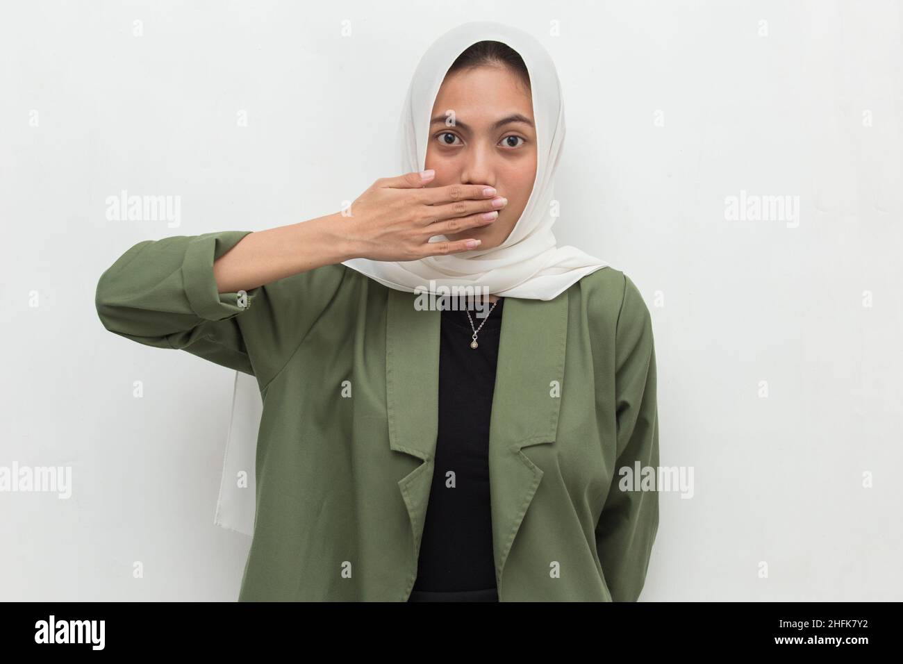 Young asian woman wearing hijab shocked covering mouth with hands for mistake. Secret concept. Stock Photo