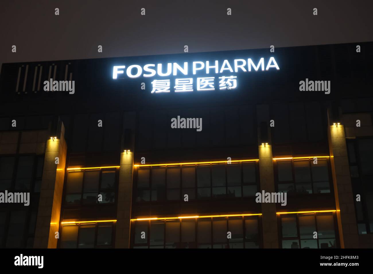 Fosun Pharma company logo on office building at night. A Chinese