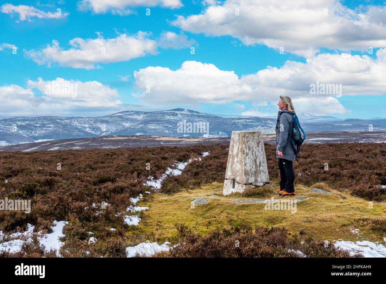 A walker at the summit cairn on Lord Arthur's Hill in the Correen Hills near Alford, Aberdeenshire, Scotland Stock Photo