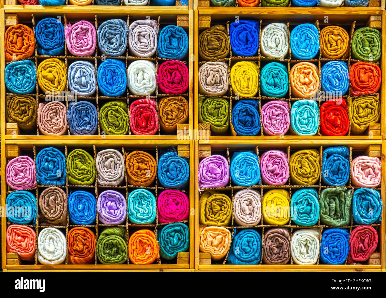 tailor store colorful textile texture rolls of fabric on shelves background Stock Photo