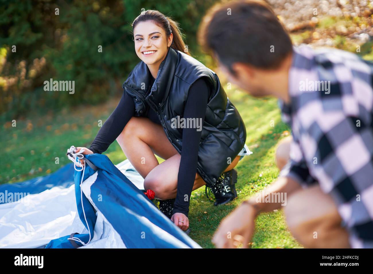 Young nice couple having fun on camping setting up tent Stock Photo