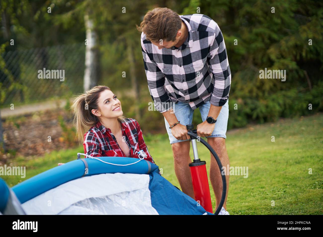 Young nice couple having fun on camping setting up tent Stock Photo