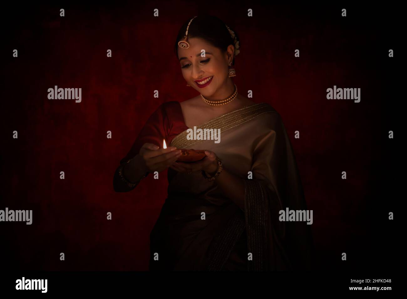 Indian woman holding diya in her hand while celebrating Diwali Stock Photo
