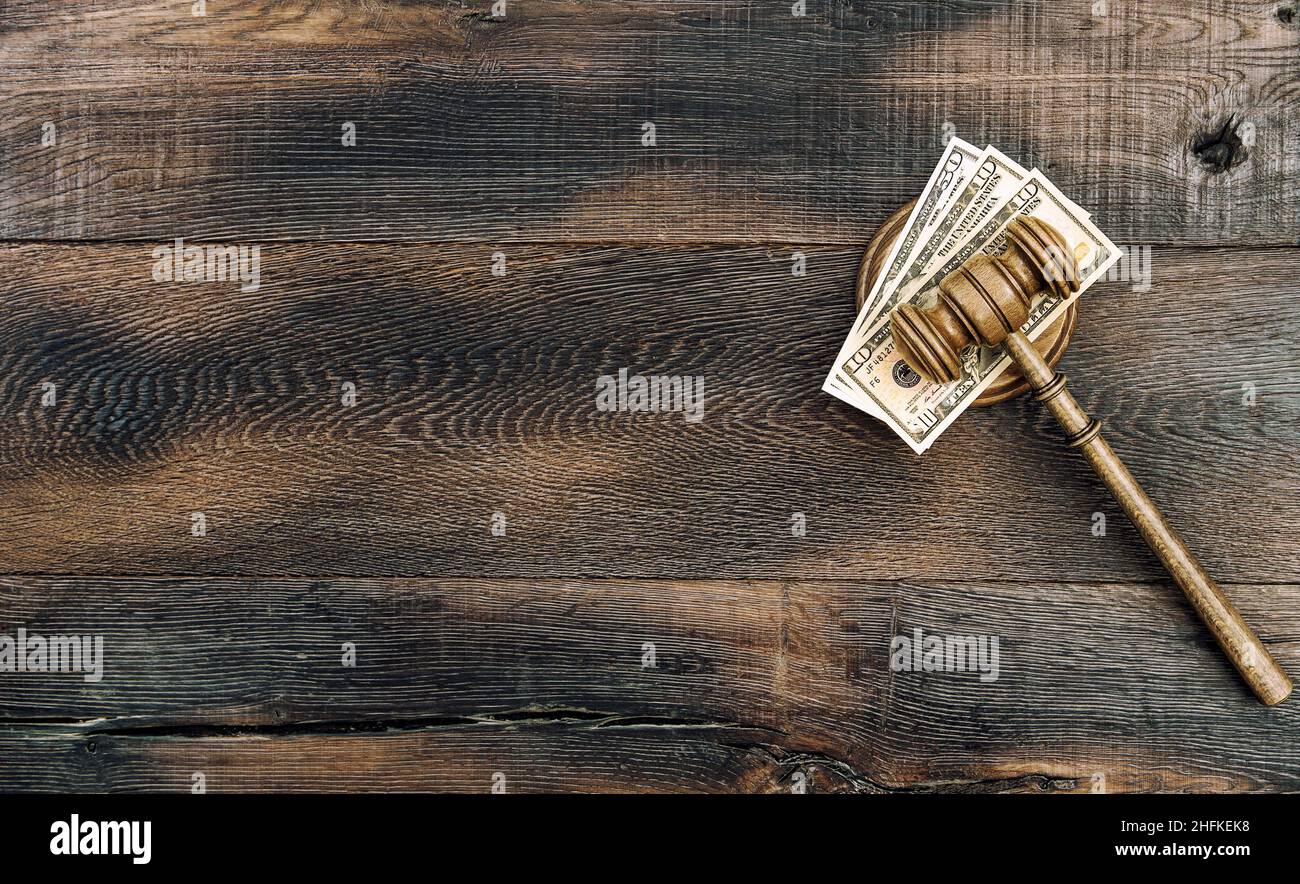 Auctioneer hammer and US dollar banknotes on wooden background. Judges gavel with soundboard Stock Photo