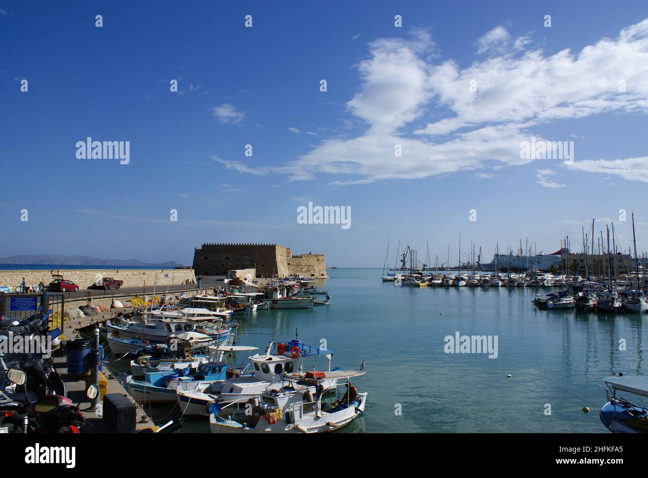 Heraklion, Crete - Greece - October 15 2010 : Historic old Venetian port, with a view of the old fortress, guarding the harbor. Colorful small fishing Stock Photo