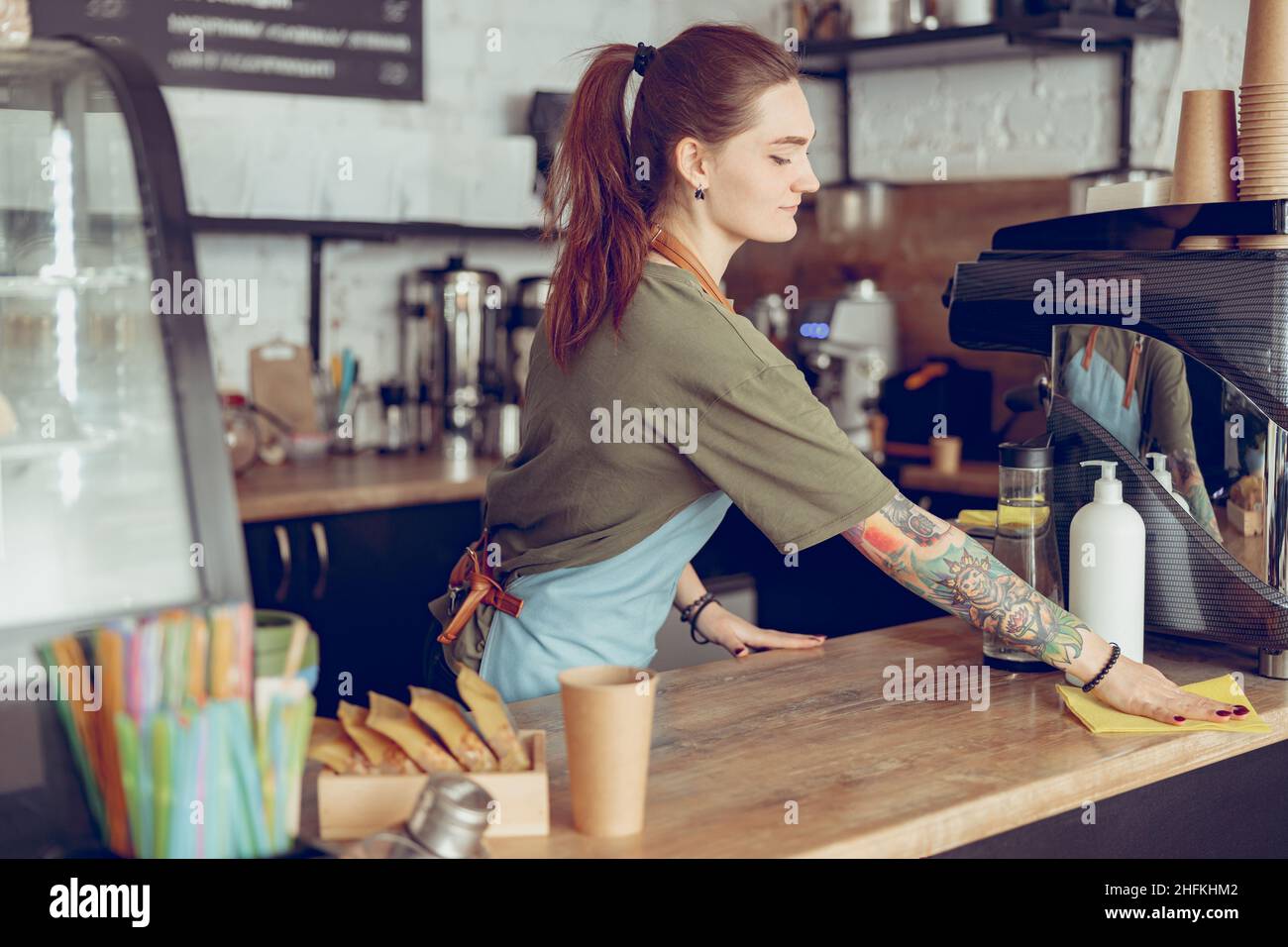 Young woman barista cleaning counter in cafe Stock Photo Alamy