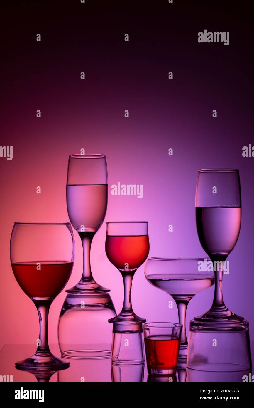 Glassware of different sizes against colorful background Stock Photo