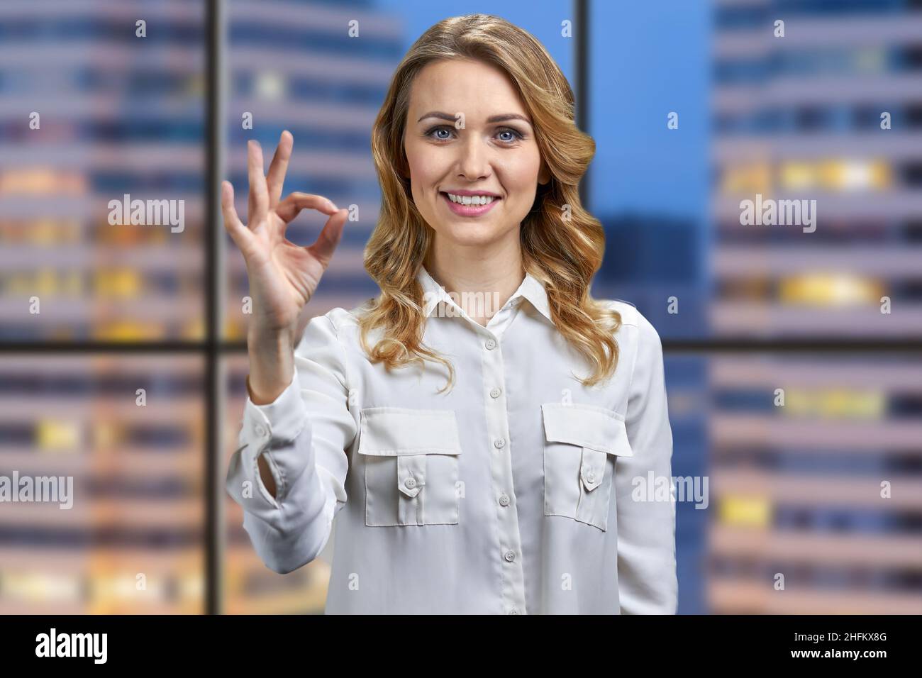 Portrait of attractive young business woman showing okey symbol. Stock Photo