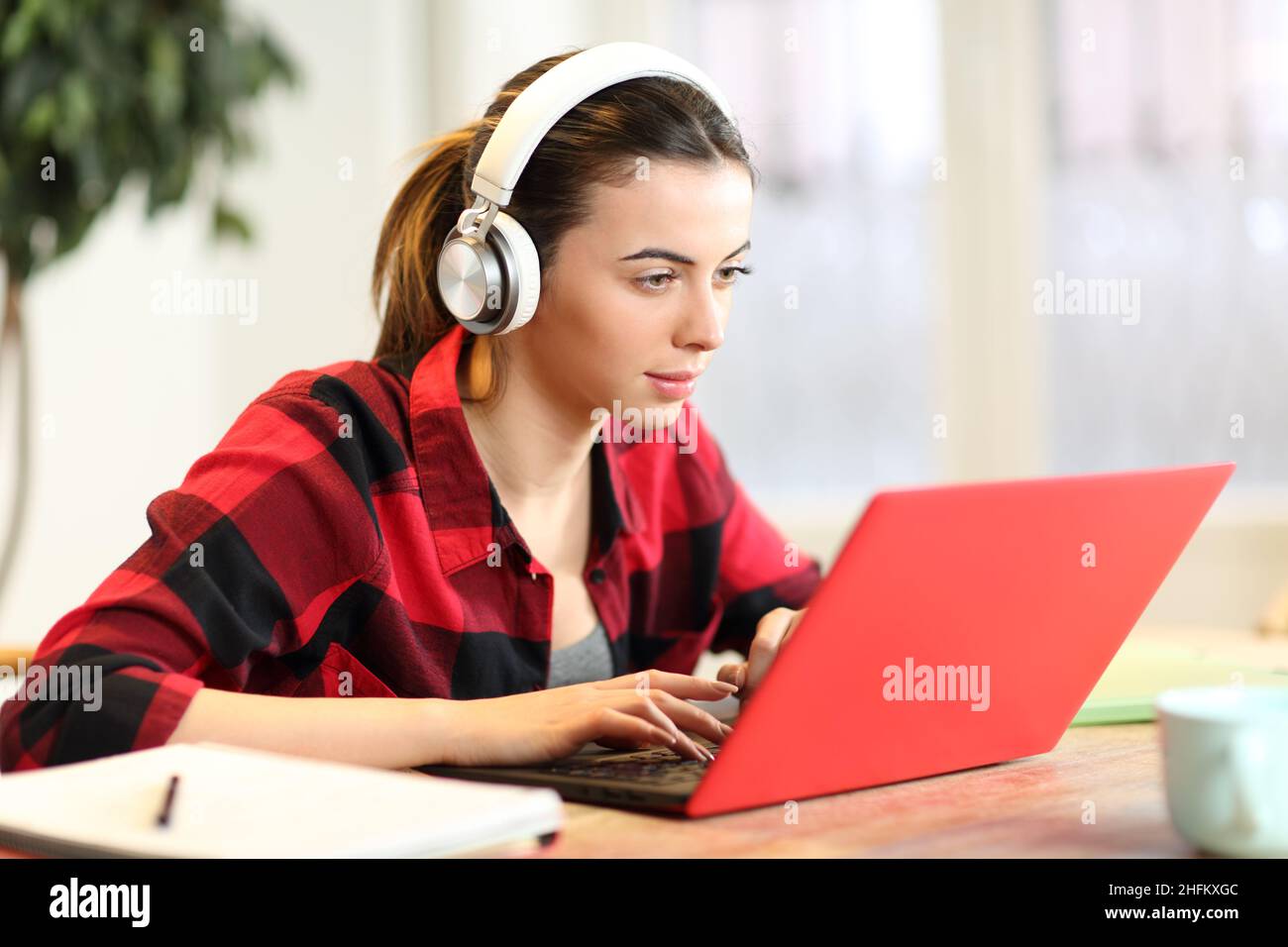 Concentrated student e-learning with laptop and headphones at home ...