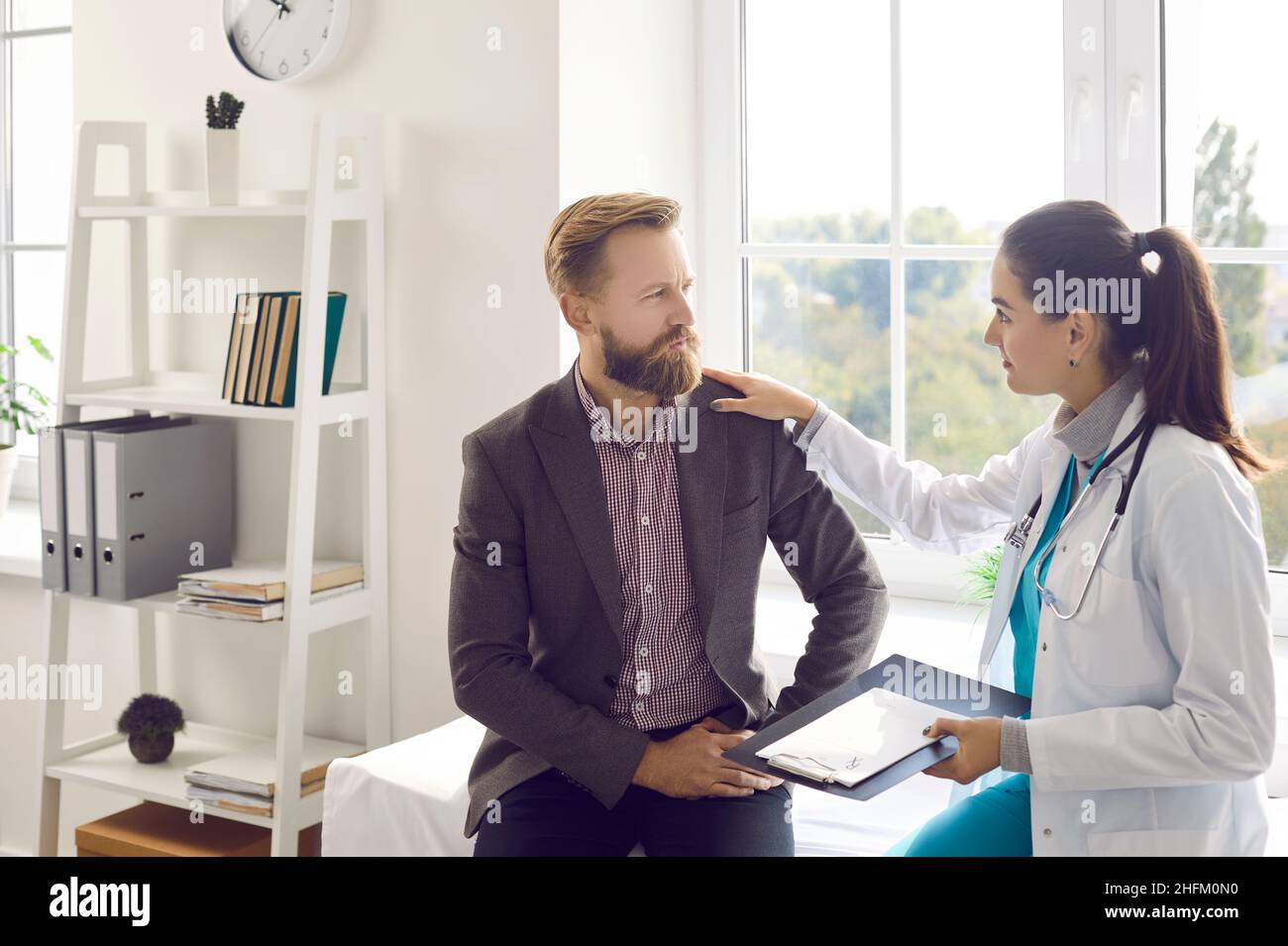 Man listening to doctor who is reassuring him and giving him advice, support and hope Stock Photo