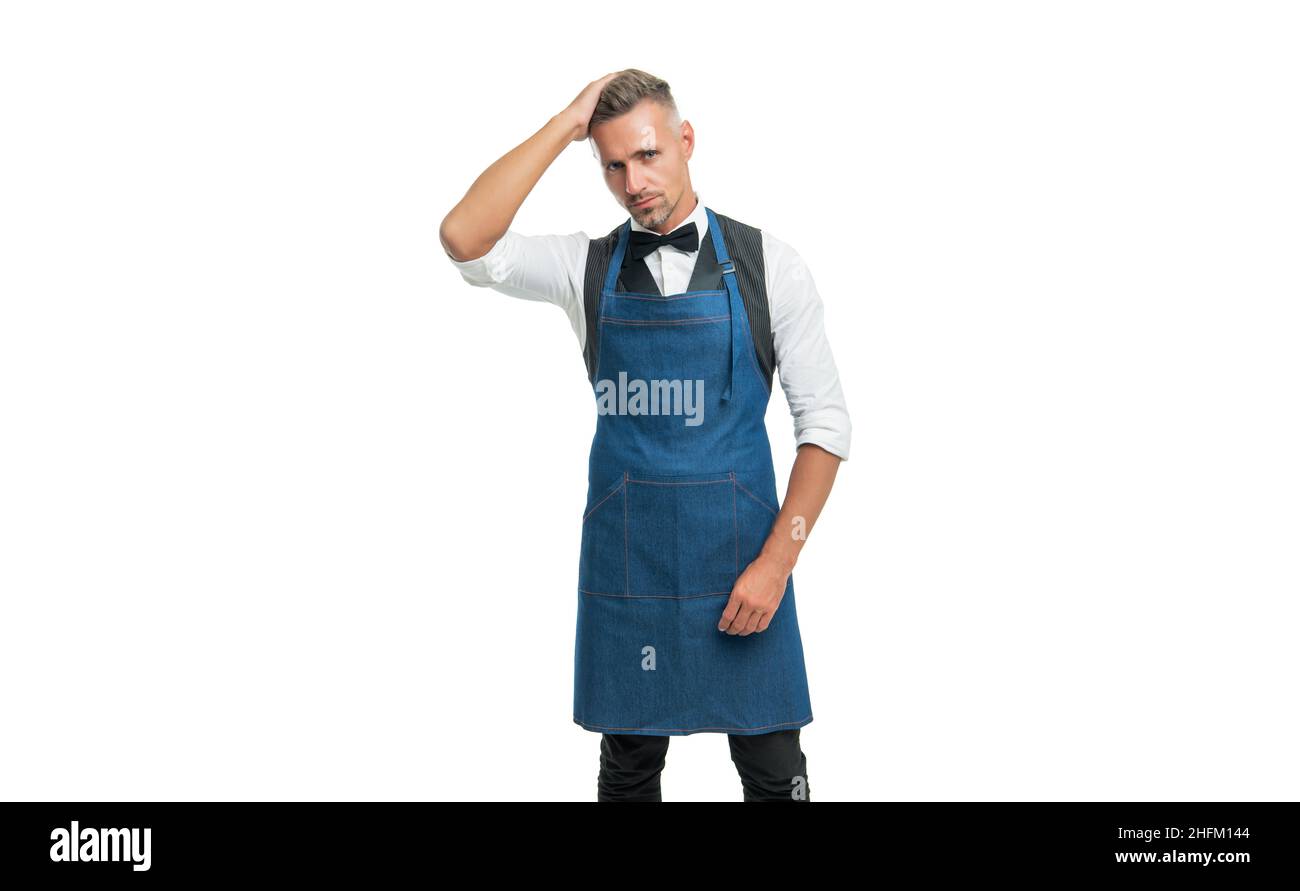 Serious man in bow and bartender apron fixing hair isolated on white, barkeeper Stock Photo