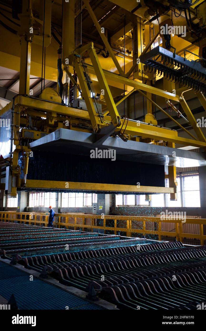 Copper metallurgical plant. Overhead crane of electrolysis refining machine lifting ready refining copper plates (ingots). Kazzinc company. Stock Photo