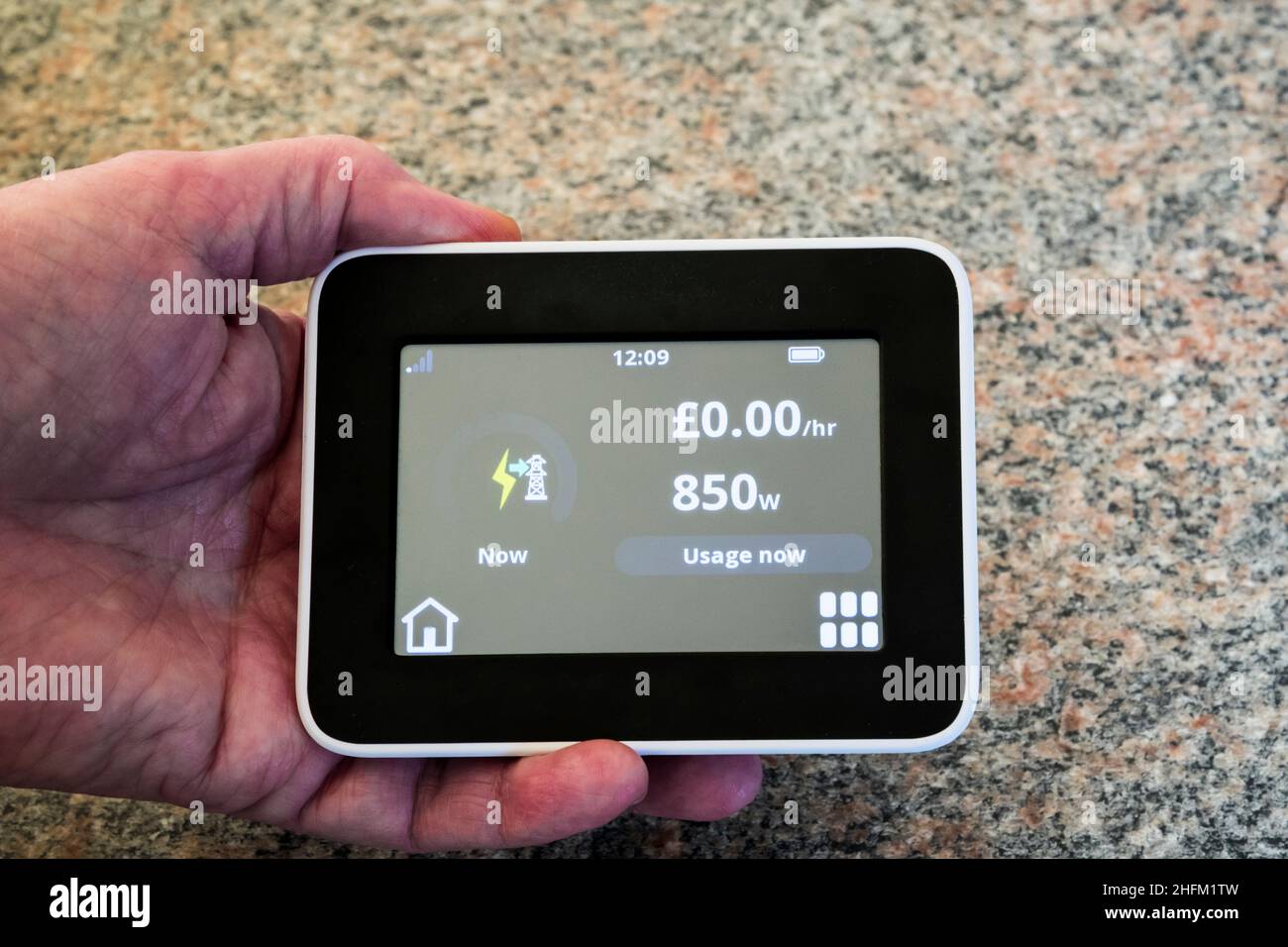 A smart meter display on a house with PV cells shows that it is not paying for electricity and is exporting to the grid. Stock Photo
