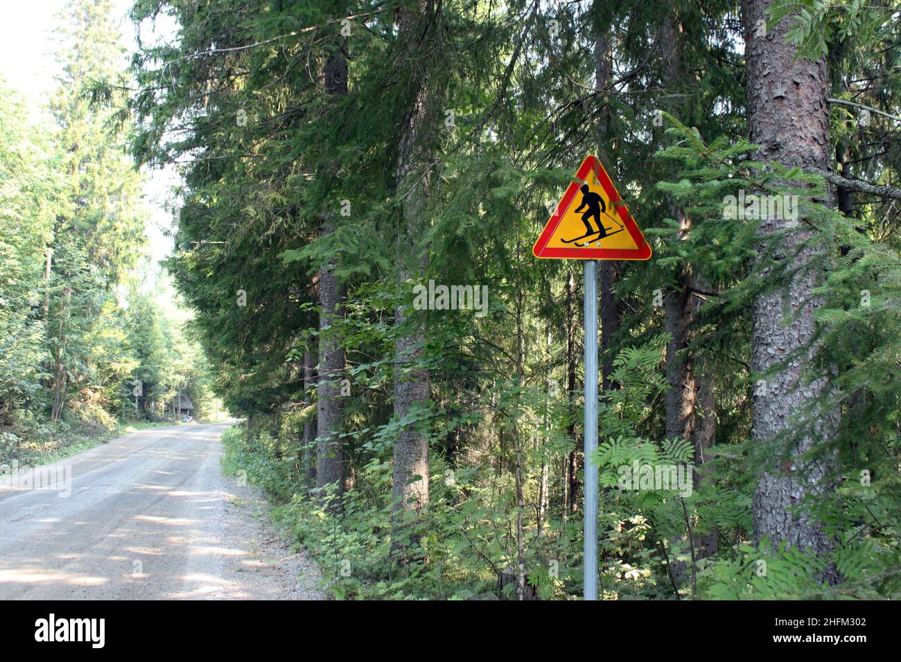 The warning sign by Finnish roads. The skiers can pass the road.  Funny in summer. Stock Photo