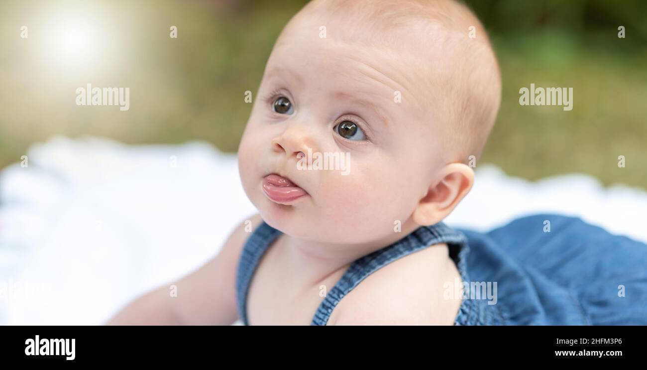 Portrait of cute baby girl lying outdoors, light effect Stock Photo - Alamy