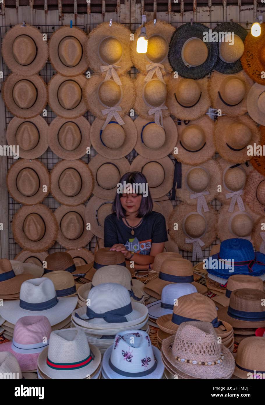 lady selling hats at a market stall on the thailand island of phuket