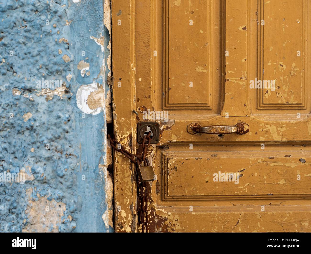 A brown wooden door closed with a padlock Stock Photo