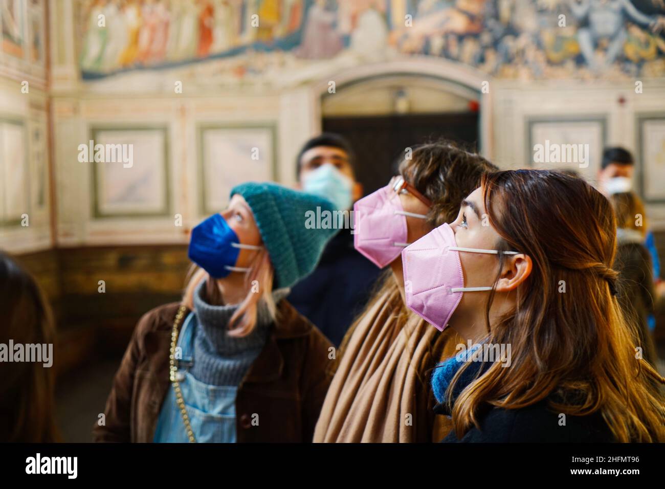 Young female visitors wear anti covid masks in Scrovegni Chapel. Padua, Italy - January 2022 Stock Photo