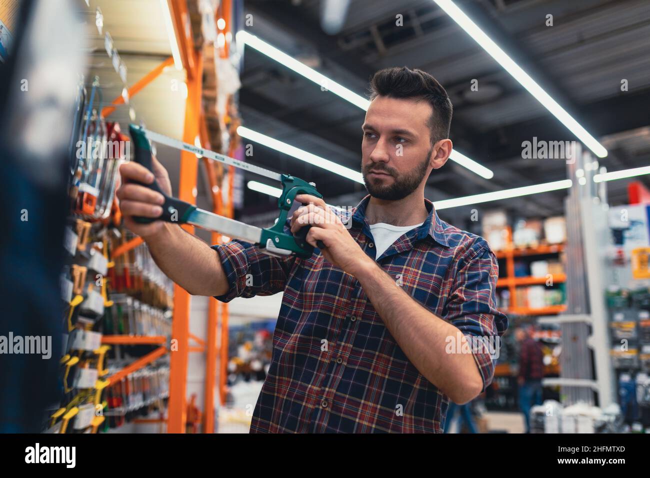 Guy Using Hacksaw Young man chooses tool in hi-res stock photography and images - Alamy