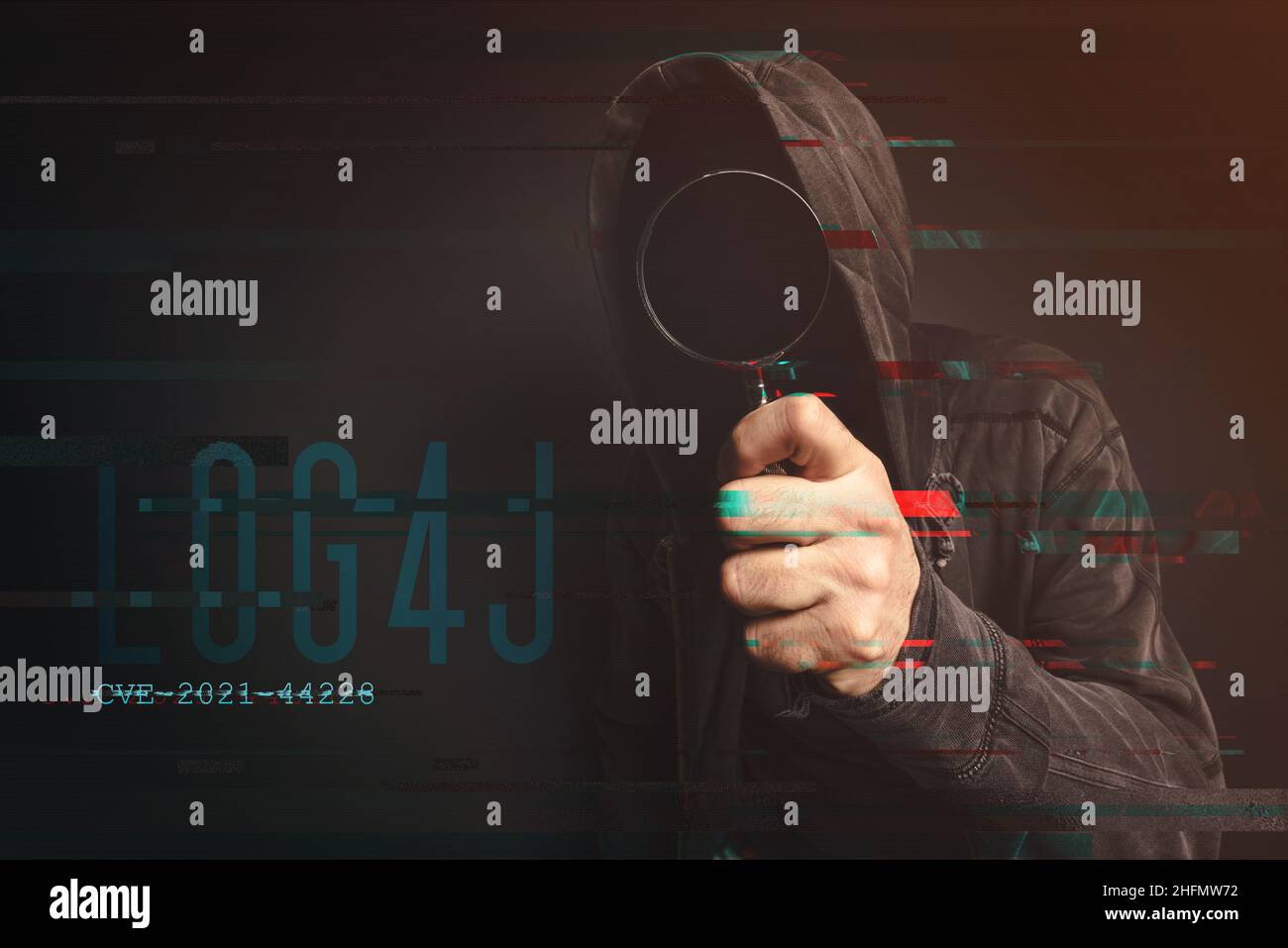 Hooded computer hacker in cybersecurity vulnerability Log4J concept with digital glitch effect Stock Photo
