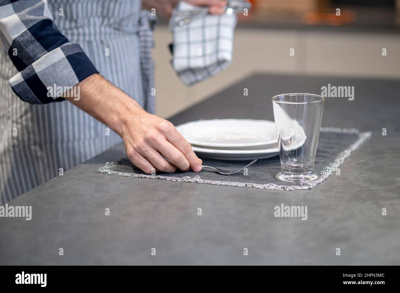Male hand putting fork on napkin near plate Stock Photo