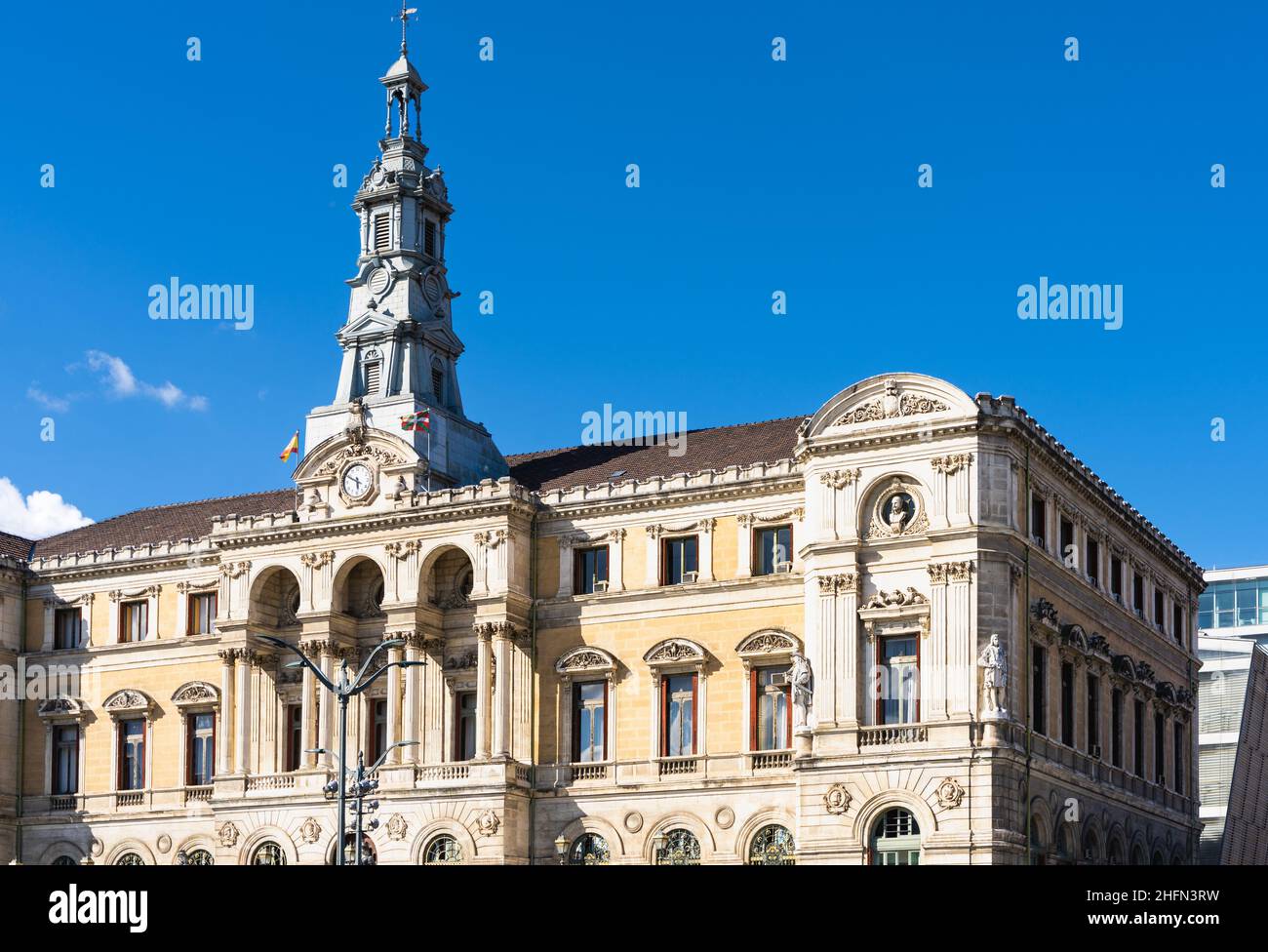 Bilbao City Hall front facade with Spanish and Basque flags on sunny day. Eclectic style architecture built in 1892 Stock Photo