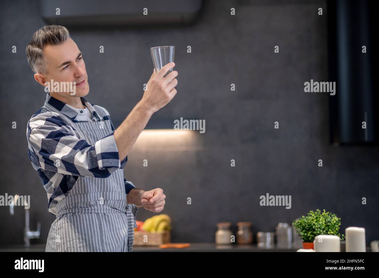 Man looking at glass in outstretched hand Stock Photo