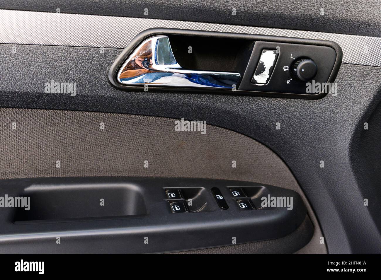 Car door handle. Inside the drivers door of a new car with a window