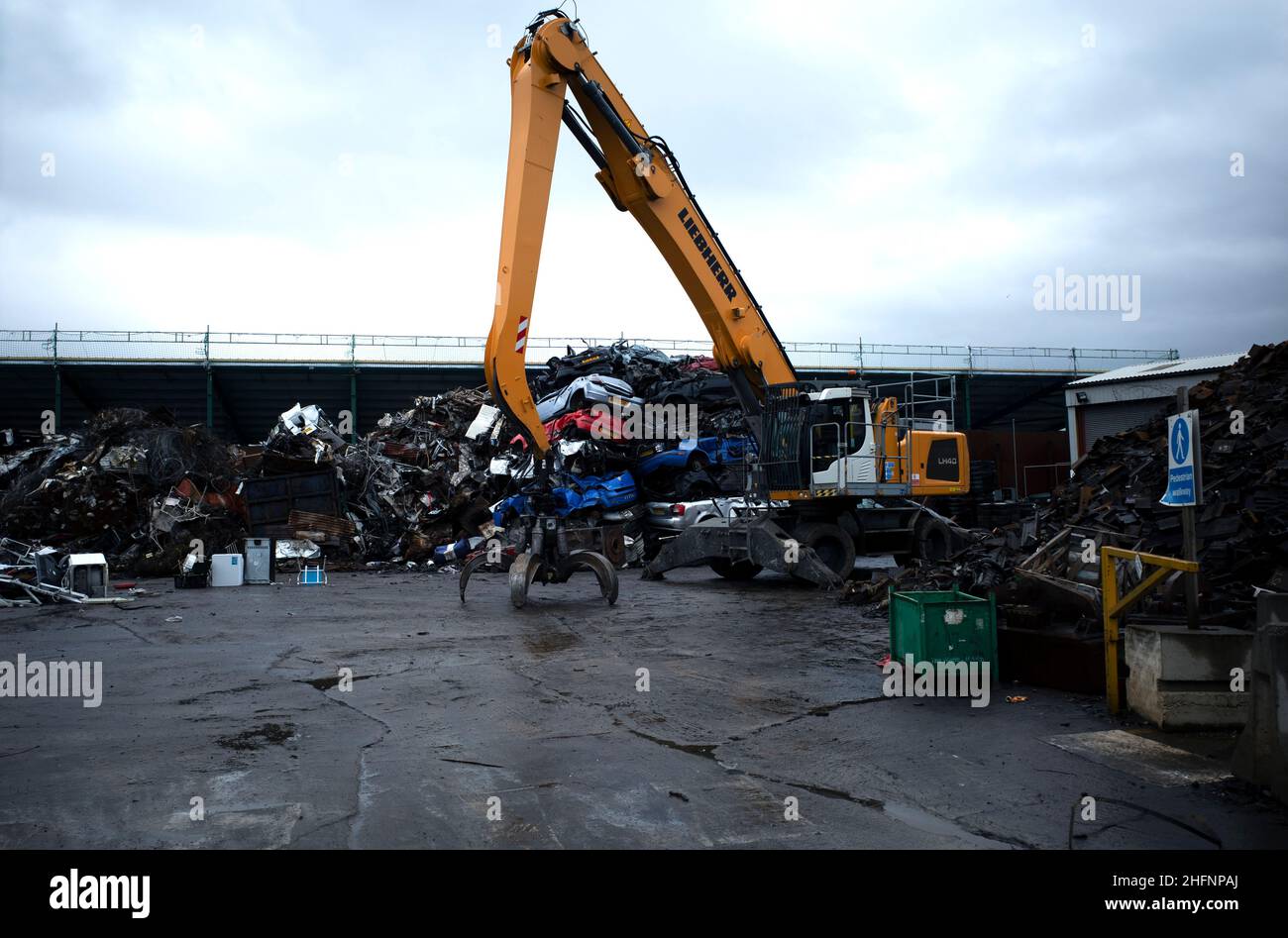 A small scrap yard in a North Yorkshire Industrial  Estate mainly handling scrap cars with a Liebherr LH40 Crane Stock Photo