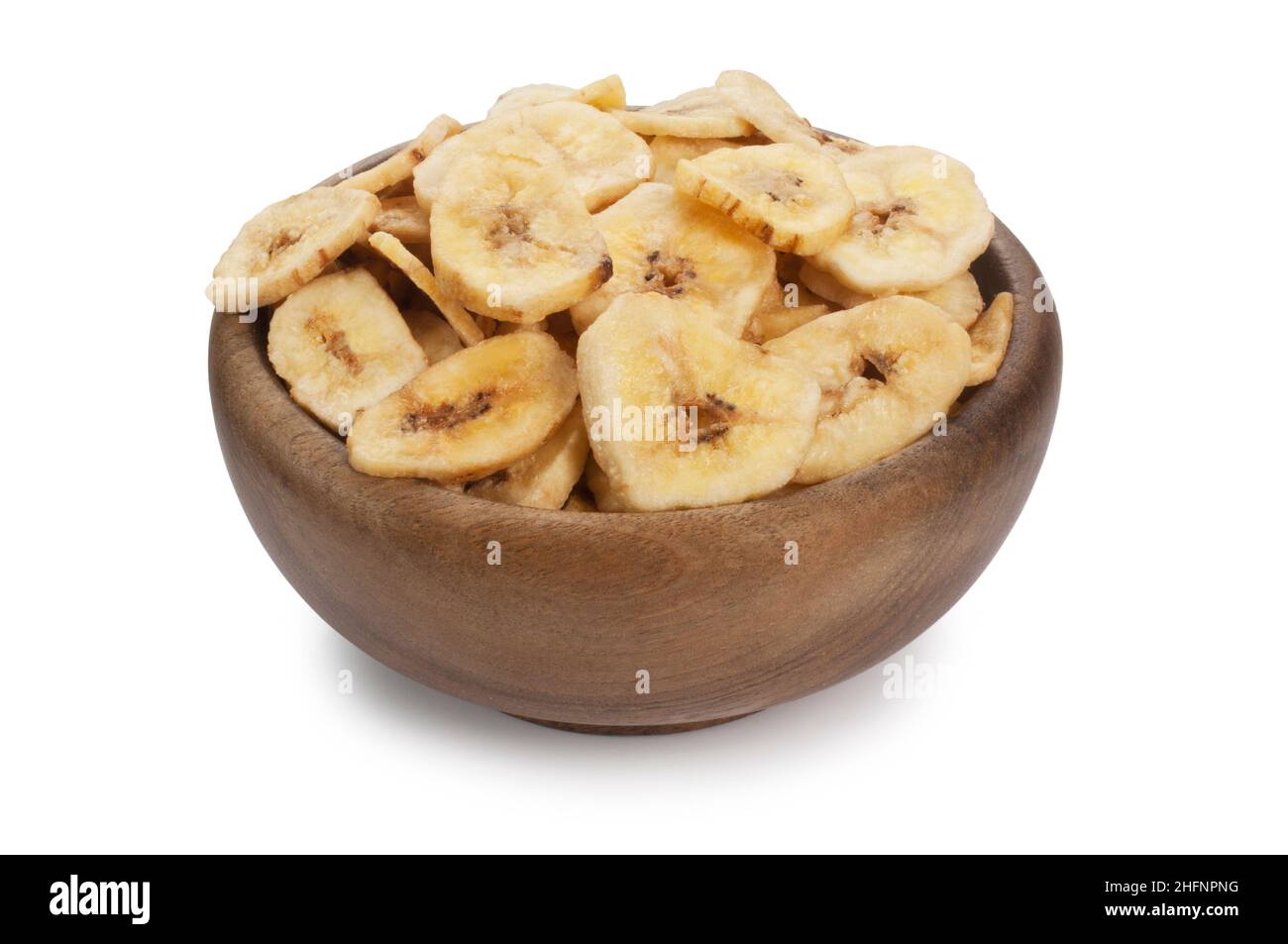 Studio shot of dried banana chips in a wooden bowl cut out against a white background - John Gollop Stock Photo