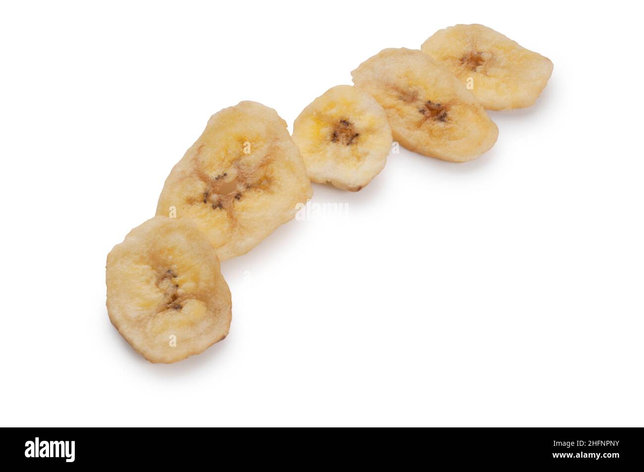 Studio shot of dried banana chips cut out against a white background - John Gollop Stock Photo