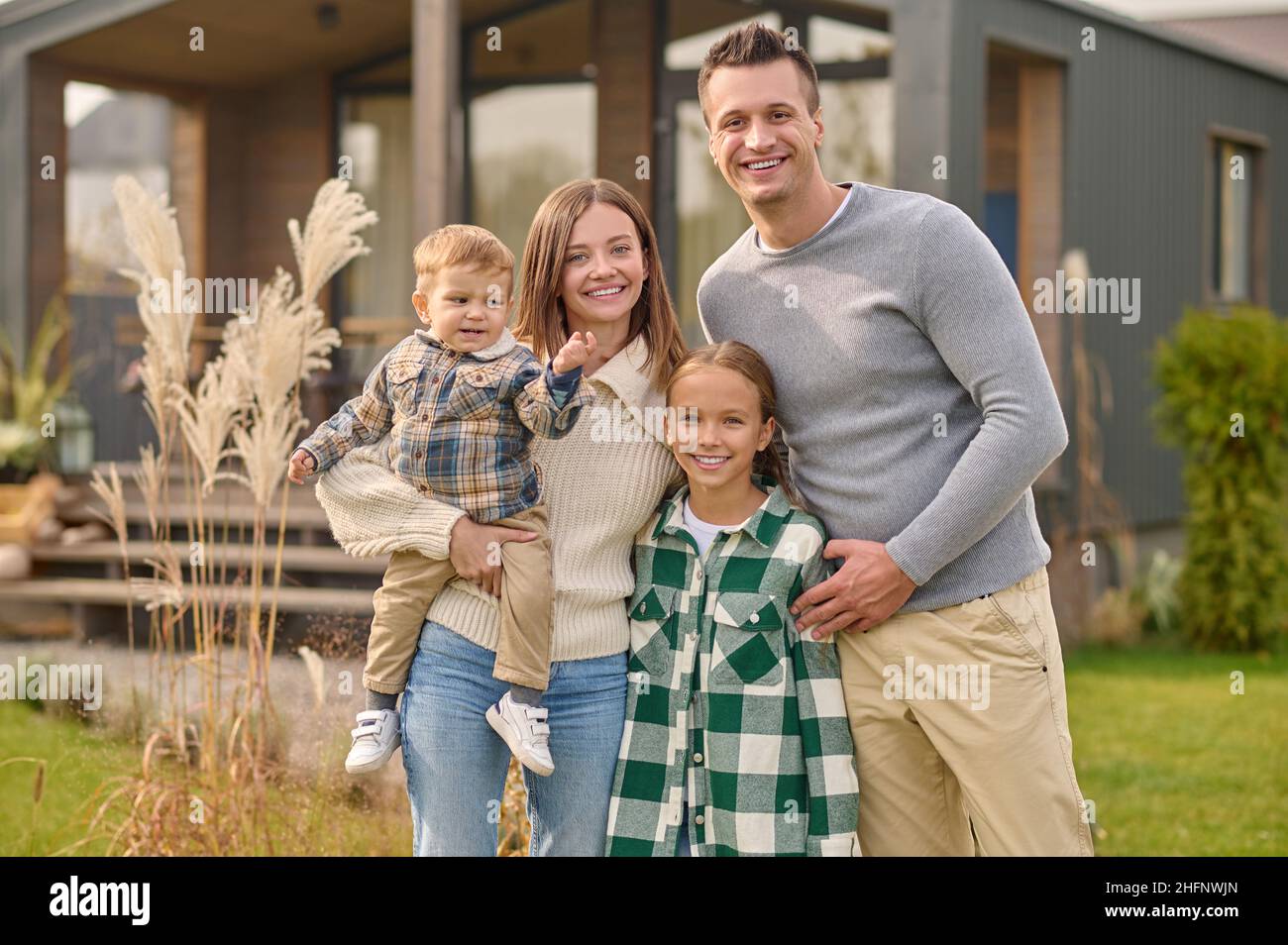 Man woman with child and girl looking at camera Stock Photo - Alamy