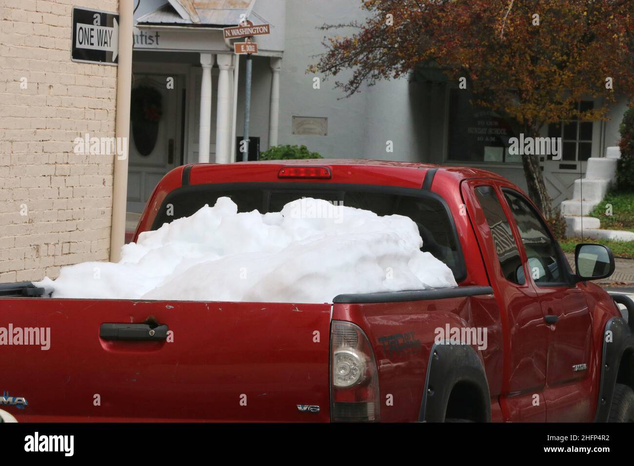 Sonora, CA: 12/31/21 – Red truck with the bed filled with a mound of snow. Stock Photo