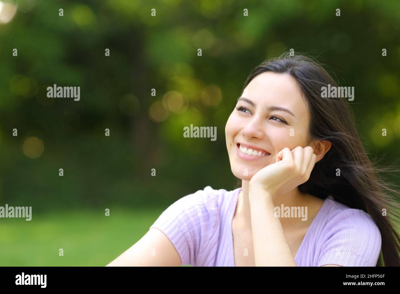 Happy asian woman thinking looking at side in a park Stock Photo