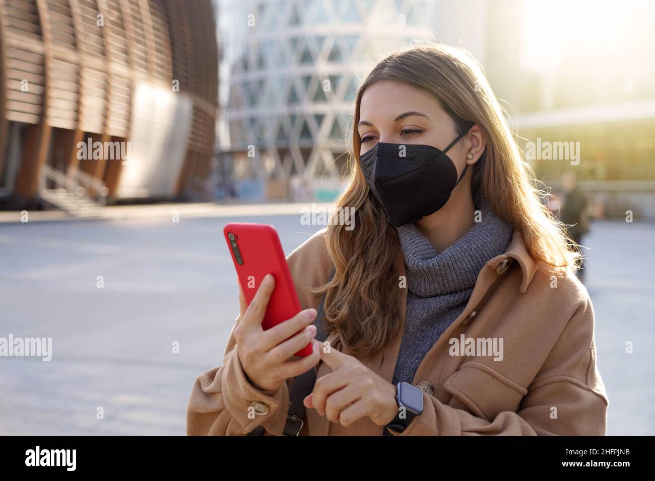 Young business woman wearing KN95 FFP2 mask using mobile phone app in ...