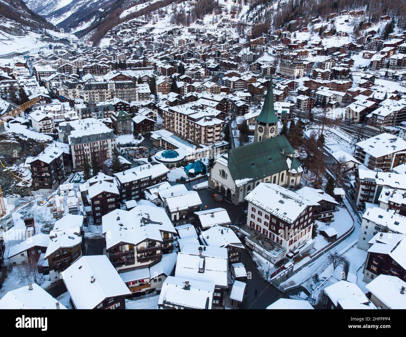 Aerial view of the snow covered Zermatt village with its church in the ...