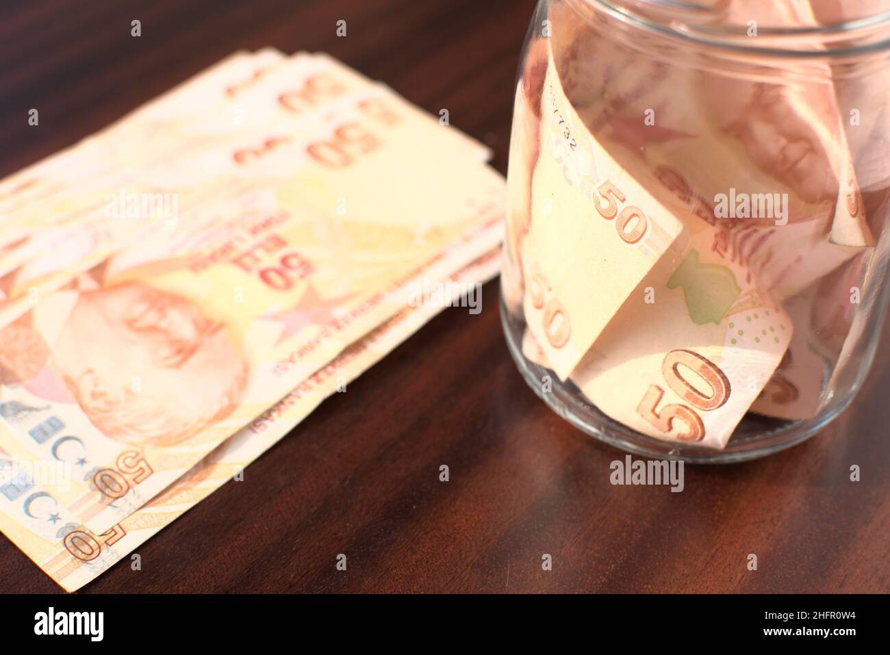 Some 50 Turkish Liras to save up in a jar on a brown background. Stock Photo