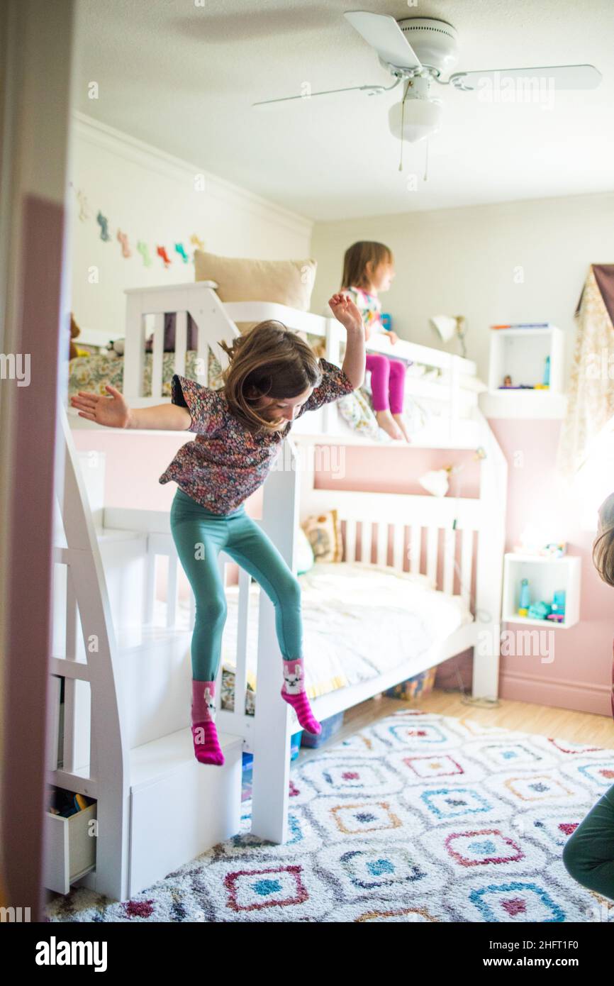 Young girl in midair, jumping off bunk bed in bedroom Stock Photo Alamy