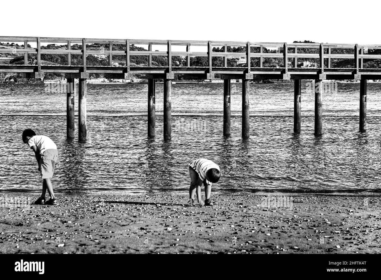 Lisbon, Portugal- 19 May, 2021: Children playing on the shore of The Tagus River and visiting Belem Tower in a low tide day in Lisbon in a sunny day o Stock Photo