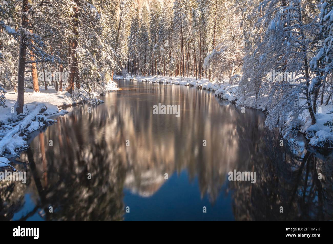 Snow-covered trees and their reflections on the Merced River in Yosemite National Park, California, USA. Stock Photo