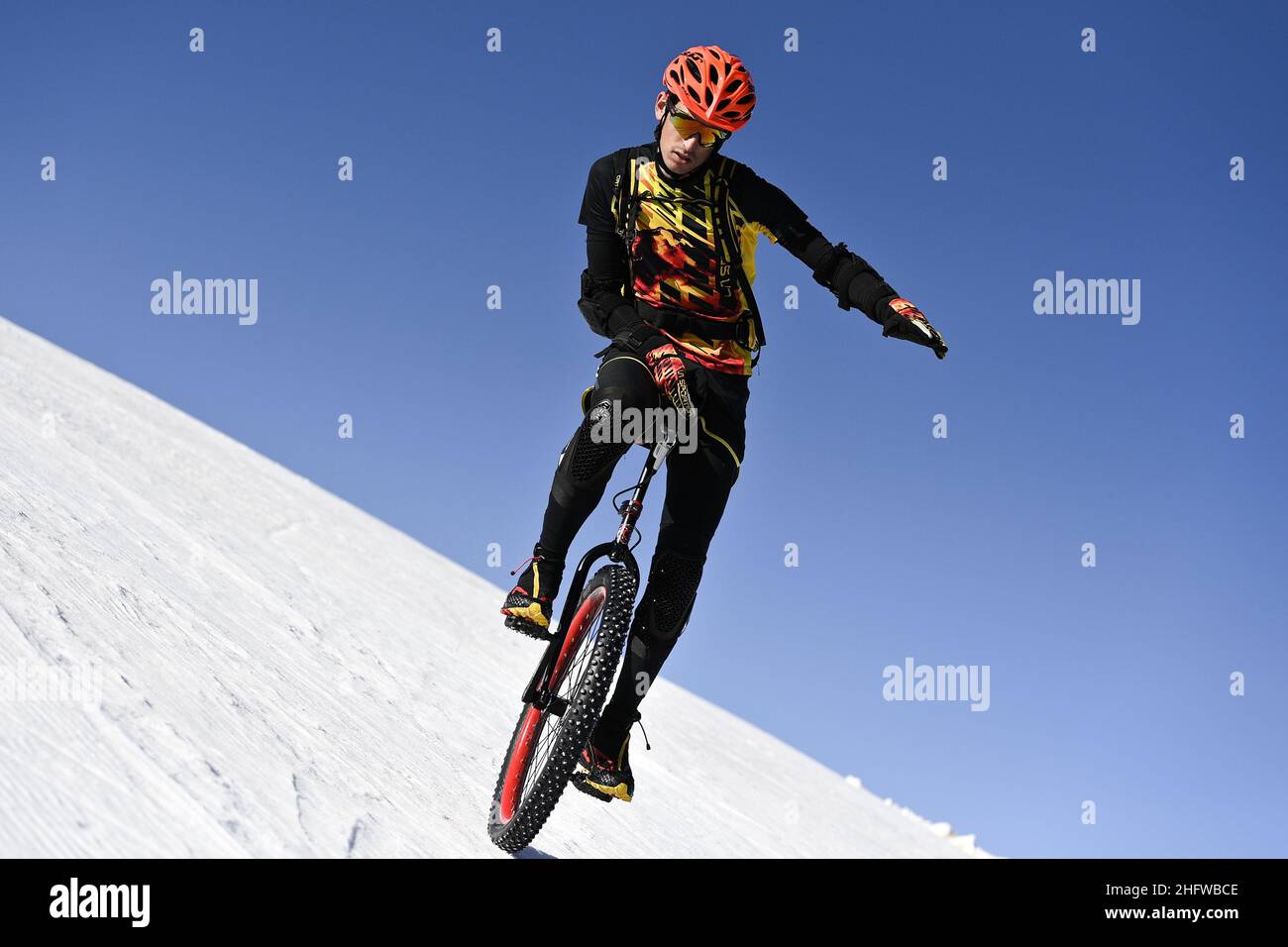 LaPresse - Marco Alpozzi February 25, 2021 Artesina (CN), Italy sport With the slopes throughout the Alps closed due to the Covid-19 pandemic, Marco Liprandi, 22 years old from Frabosa Soprana (CN), alpine ski instructor and coach, brings his passion for mono cycle to the ski slopes. After the ascent to Pian della Turra from Artesina, he begins the descent on the single cycle with spiked wheel. A single disc brake controlled from under the saddle ensures braking, while the free left arm moves in search of balance. Stock Photo