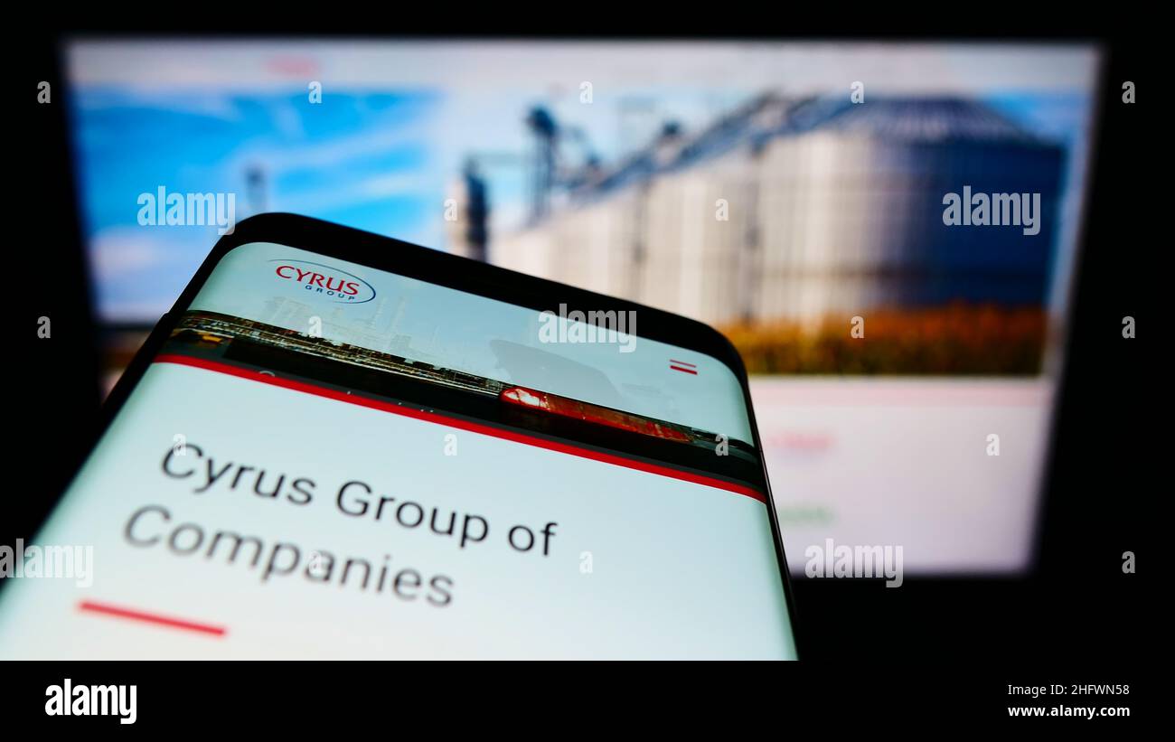 Mobile phone with business website of conglomerate Cyrus Group of Companies on screen. Focus on phone display. Stock Photo