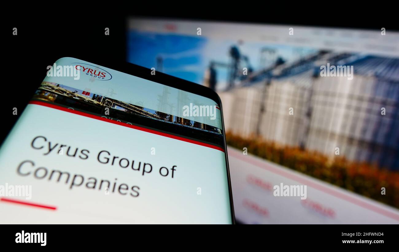 Smartphone with company website of oil and gas conglomerate Cyrus Group of Companies on screen. Focus on phone display. Stock Photo
