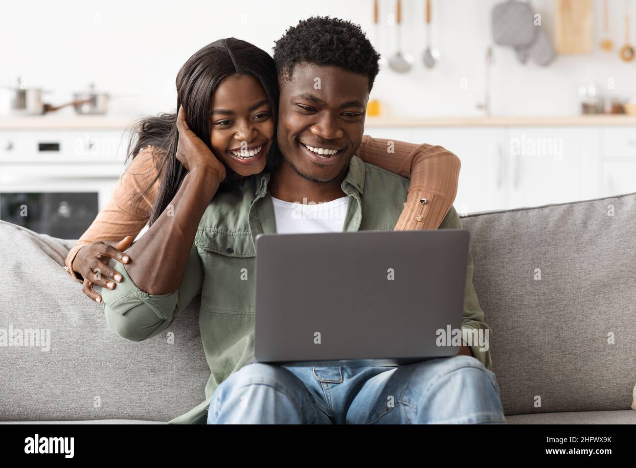 Loving black couple using laptop together home interior Stock Photo